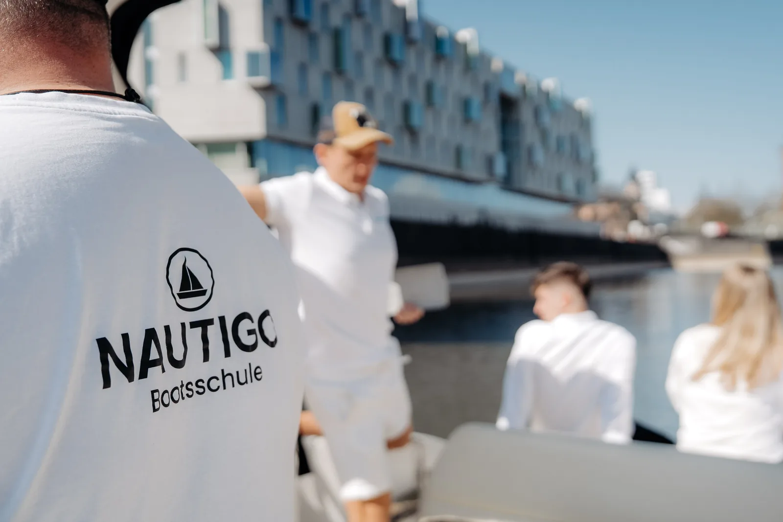 Nautigo Bootsschule Shirt Am Steg, Im Hintergrund Die Kursgruppe